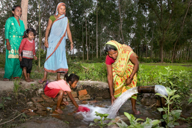 Chanda Devi stands at a water point in her village’s new irrigation system, which she worked as a Project Coordinator to help install.    UN Women/ Sanjog Tuladhar