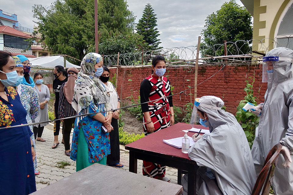 Mithu Tamang waits in a queue to get her temperature checked by staff at WHR's women-managed quarantine facility. Photo: UN Women/Ashma Shrestha