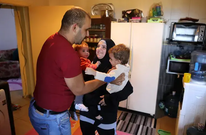 Ahmed Moustafa, a school principal, and Samiha Ghimrawi, a science teacher, at home in Tripoli, Lebanon, with their two children. Photo: UN Women/Marwan Tahtah.