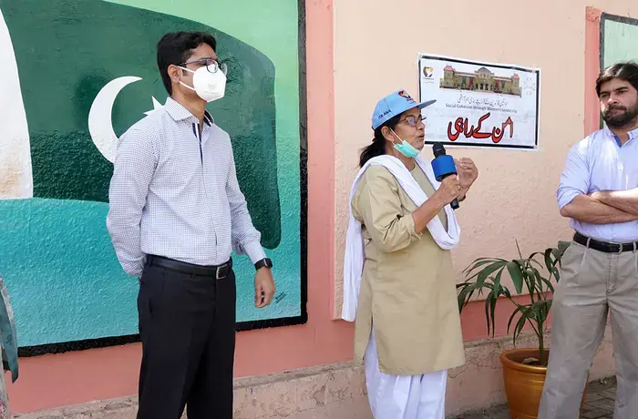 Shamim Awan, an artist from Karachi speaks in front of the murals she helped design, depicting a more tolerant, peaceful society.  Photo: PAIMAN