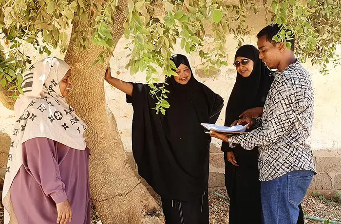 UN Women programme beneficiaries discuss the future of the Village Saving and Loan Associations (VSLAs) in the shade of a tree. Photo: UN Women/Aijamal Duishebaeva