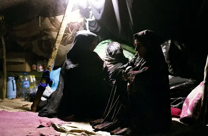 Hanifa and her two neighbours huddle in a makeshift tent to mourn those they’ve lost.