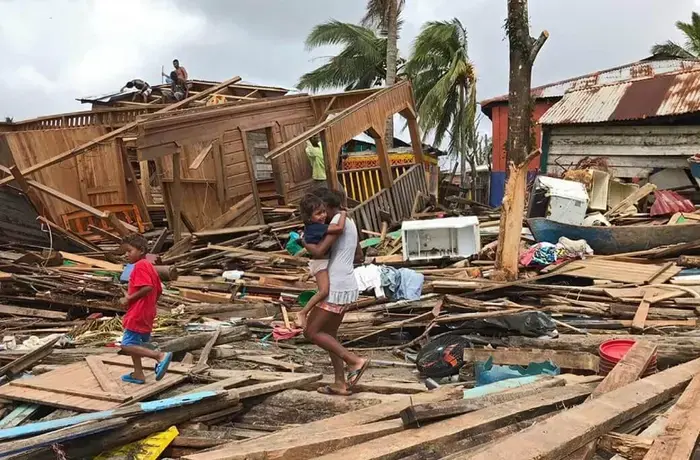A mother and her children walk through ruined housing in the wake of Hurricane Iota in Puerto Cabezas, Nicaragua. Photo: UNICEF/Inti Ocon/AFP-Services.