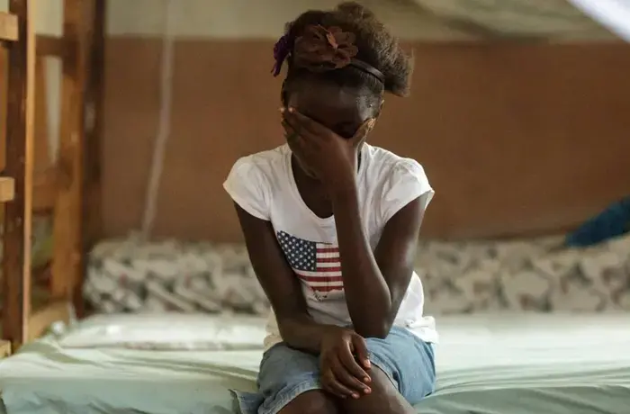 Rebecca (name changed), 10, sits on her bed in the dorm of the safe house of UNICEF partner NGO Amazonian Initiative Movement in the town of Masethleh, Port Loko District, Sierra Leone. She ran away from her home where her familiy was planning on training her as a female genital mutilation practioner. Photo: UNICEF/UNI150843/Asselin.