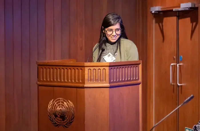 Sushmita S. Preetha speaks at a podium with the United Nations logo