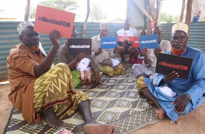 Un grupo de hombres sostiene carteles contra la MGF en las sesiones de sensibilización. Foto: cortesía de Men End FGM.