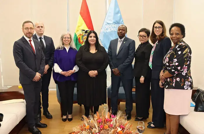 UN Women Executive Board members stand together for a group photo in a meeting room.