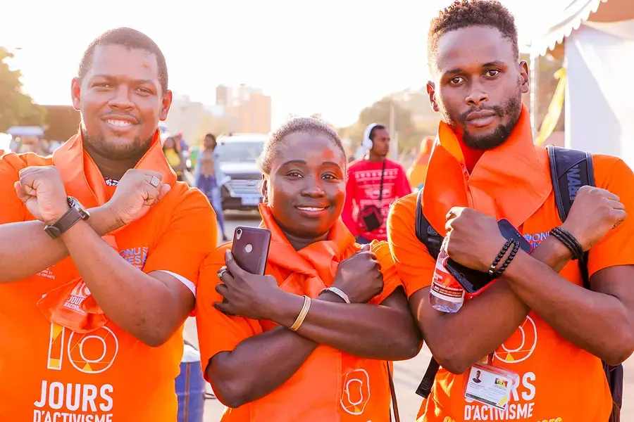 Three young activists wear orange during the sixteen days of activism against gender-based violence. 