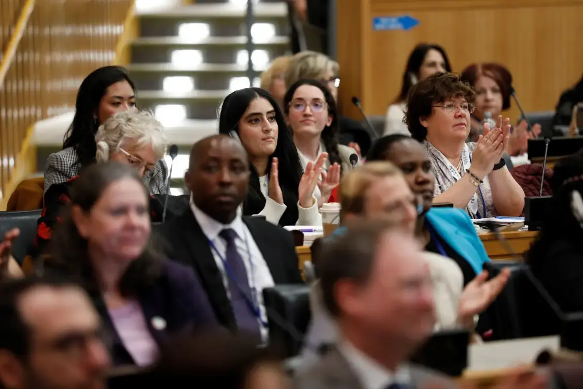 A photo of the event audience shows people clapping