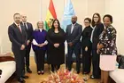 UN Women Executive Board members stand together for a group photo in a meeting room.