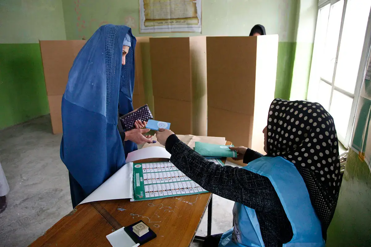Una funcionaria electoral y una votante en un colegio electoral de Kabul
