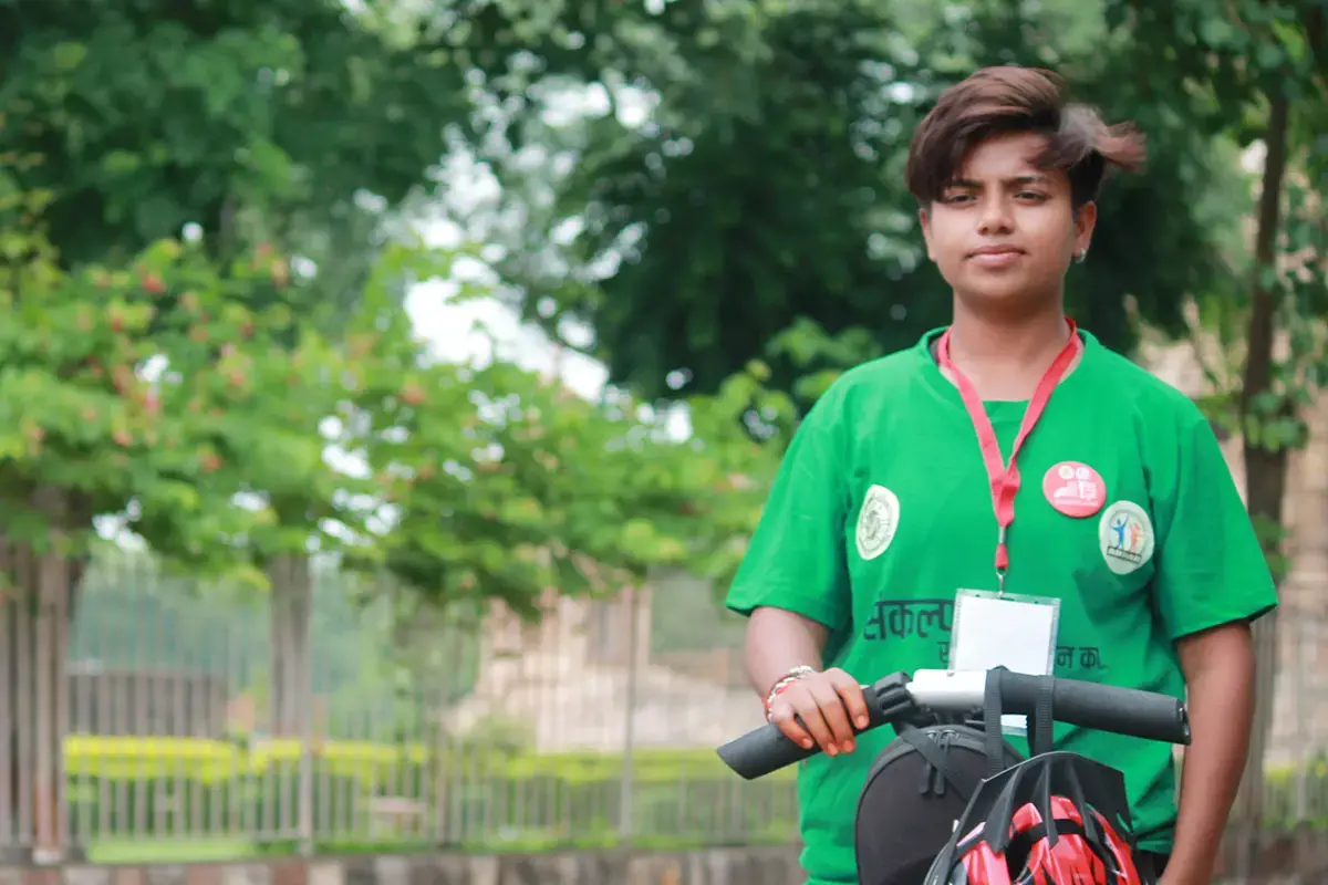 A young woman with a tour-guide badge stands on a scooter