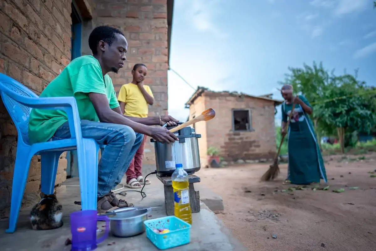 Un padre de la región de Singida, Tanzania, cocina con su familia. Foto: ONU Mujeres Tanzania.